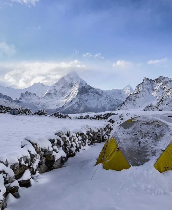 Tents in the snow below mountains