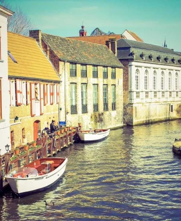 Boats on a canal between old houses
